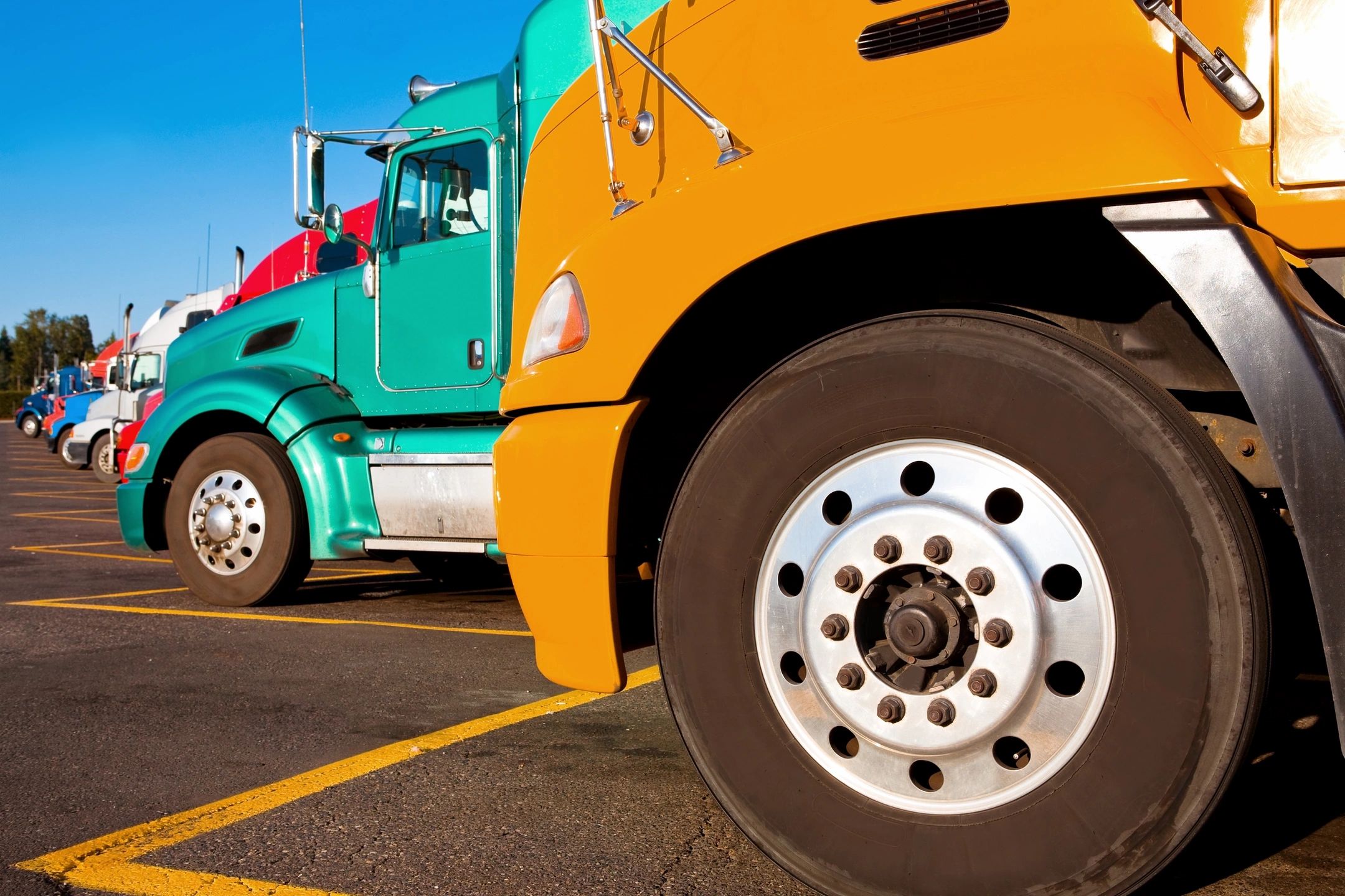Close-up of colorful semi-truck wheels parked side by side.